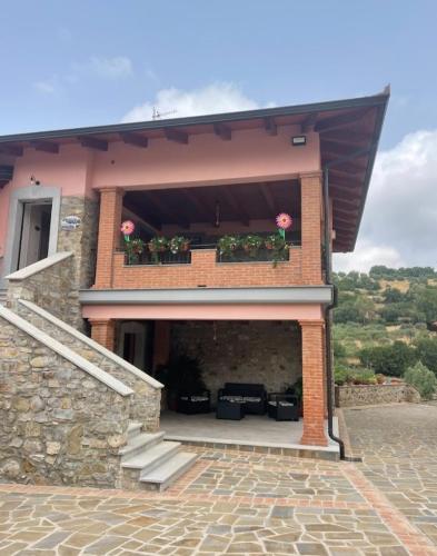 a house with a balcony with pink flowers on it at Tenuta il Giardino di Eros in Albanella