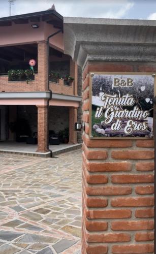 a sign on a brick wall in front of a building at Tenuta il Giardino di Eros in Albanella