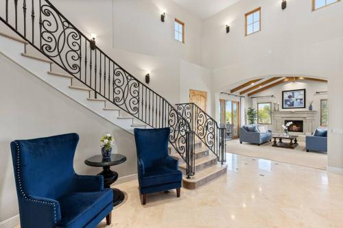 a living room with two chairs and a staircase at Mediterranean Haven with Views in Escondido in Escondido