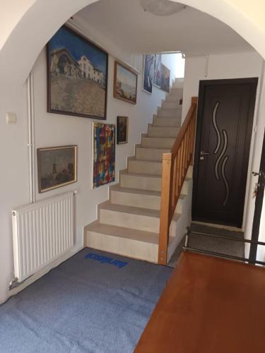 a hallway with a staircase with a door and a stair rug at Britania in Bran
