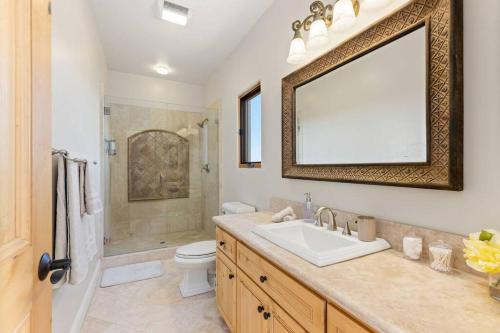 a bathroom with a sink and a toilet and a mirror at Mediterranean Haven with Views in Escondido in Escondido