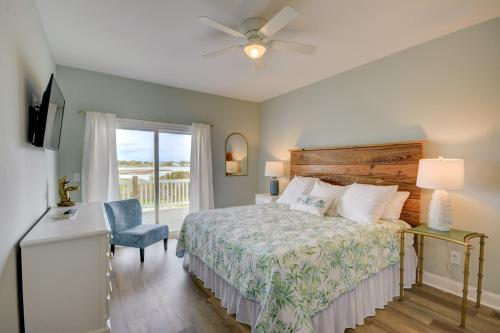a bedroom with a bed and a chair and a window at HartSea in North Topsail Beach
