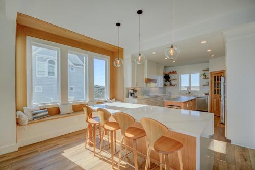a kitchen with a large white island with bar stools at 4290 Island Drive in North Topsail Beach