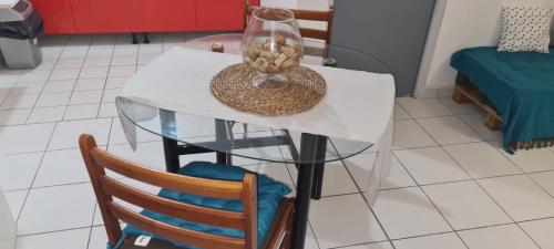a glass table with a hat and a vase on it at Paradies Caraïbes III in Les Abymes