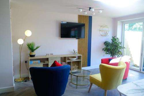 ein Wohnzimmer mit zwei Stühlen und einem Fernseher in der Unterkunft The Wave Cottage - 3 Bedroom with off road Parking for 3 Cars or Vans & EV point in Pilning