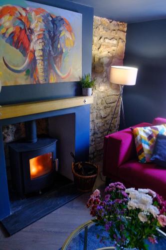 a living room with an elephant painting over a fireplace at The Wave Cottage - 3 Bedroom with off road Parking for 3 Cars or Vans & EV point in Pilning