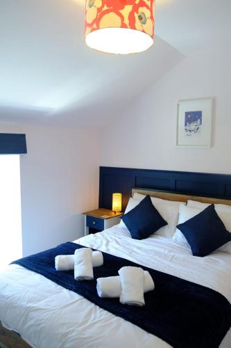 a bedroom with a large bed with two towels on it at The Wave Cottage - 3 Bedroom with off road Parking for 3 Cars or Vans & EV point in Pilning