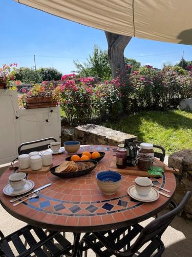 une table avec un bol de fruits dessus dans l'établissement NEW La ferme fleurie Gîte Ty Rose, à Ploubazlanec
