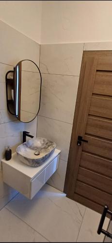 a bathroom with a sink and a mirror and a door at Apartman Hana 1 in Žgaljić