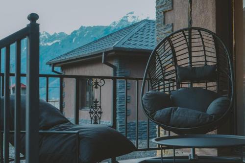 a chair sitting on a balcony with a table at Holiday Home in Stepantsminda