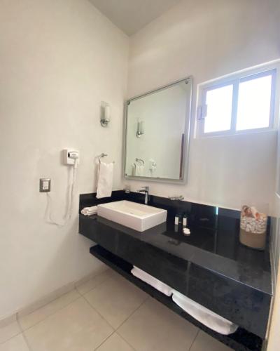 a bathroom with a sink and a mirror at Melaque Paradise in San Patricio Melaque