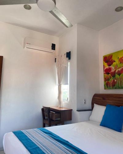 a bedroom with a bed and a desk and a window at Melaque Paradise in San Patricio Melaque