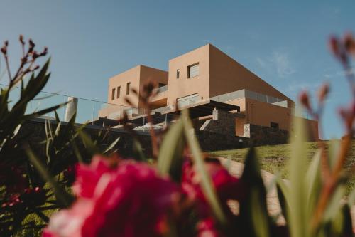 a building in the background with flowers in the foreground at Dedalos Touch Boutique Hotel in Skaleta