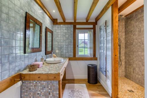 une salle de bain avec un lavabo et un miroir dans l'établissement Deux Chaumières Normandes, à La Mare Bardin
