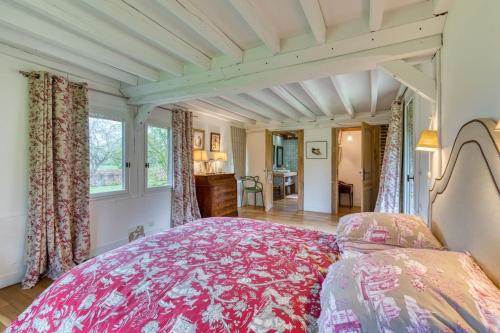 - une chambre avec un grand lit rose dans l'établissement Deux Chaumières Normandes, à La Mare Bardin