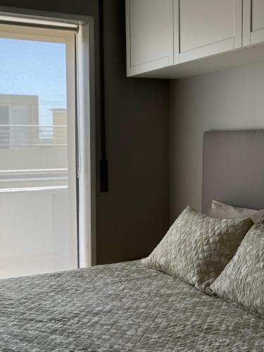 a bedroom with a bed with a window and a pillow at Esposende Apartment 8B in Esposende
