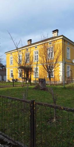 un grande edificio giallo con alberi di fronte di Löwenzahn a Scheibbs
