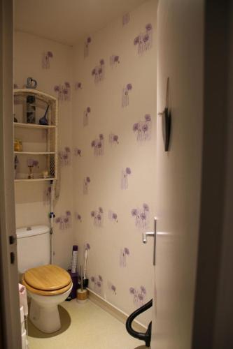 une salle de bain avec des toilettes avec des éléphants violets sur le mur dans l'établissement Danielle PICARDA, au Mans