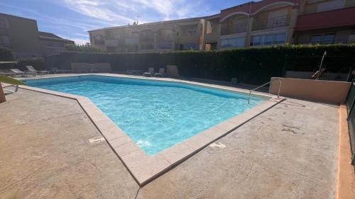 une grande piscine devant un immeuble dans l'établissement Appartement Marseillan Plage, à Marseillan