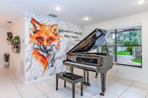 a piano in a room with a painting of a fox at Lux House Heated Spa & Free Boat Tour! in Fort Lauderdale