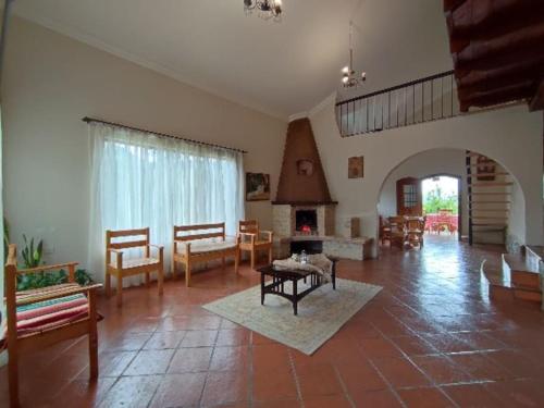 a large living room with a table and a fireplace at Residencia en Paute Azuay in Paute
