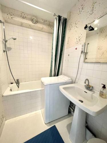 une salle de bain avec un lavabo et une baignoire et des toilettes et un lavabo dans l'établissement Résidence De La Mer - Appartement de 28m², en plein cœur du Val André à deux pas de la plage. MAE-6574, à Pléneuf-Val-André