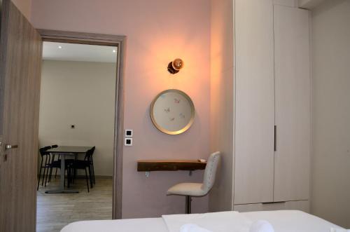 a bedroom with a clock on the wall and a chair at Villa Yvonne by EY Villas in Parga