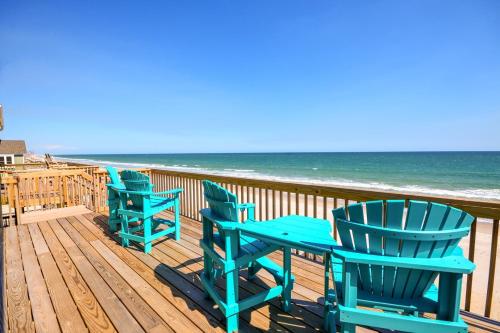 drie blauwe stoelen en een tafel op een terras met uitzicht op het strand bij Beach Bunns in Surf City