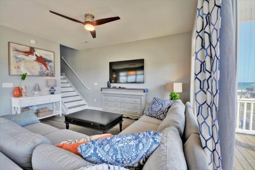 a living room with a couch and a tv at Topsail Turvy in North Topsail Beach
