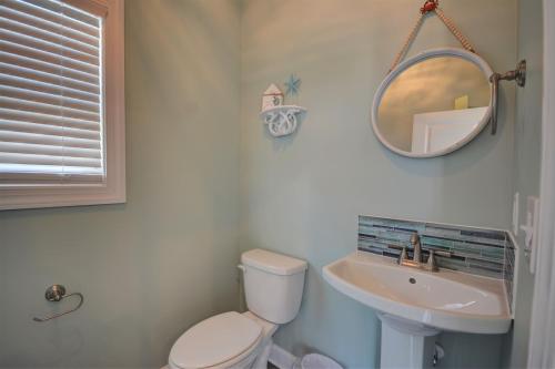 a bathroom with a toilet and a sink and a mirror at Topsail Turvy in North Topsail Beach