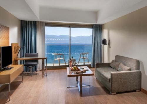 a living room with a couch and a view of the ocean at Liberty Kuşadası in Kusadası