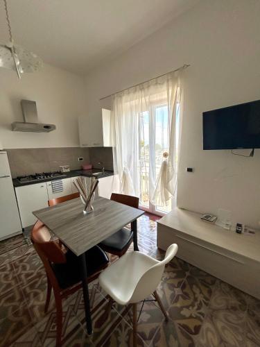 a living room with a table and chairs and a kitchen at Villa Elisa in Minturno