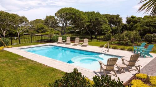 a pool with chaise lounge chairs and a swimming pool at Beyond the Sea in Thomas Landing