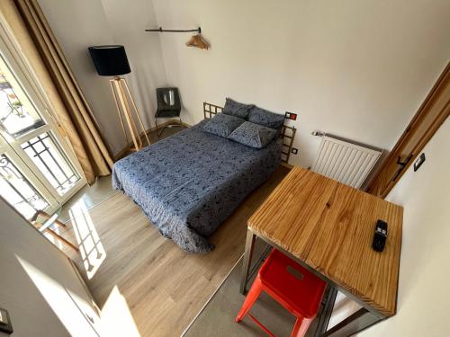 ein Schlafzimmer mit einem Bett und einem Holztisch in der Unterkunft Lotila Flats Rio Caudal in Figaredo