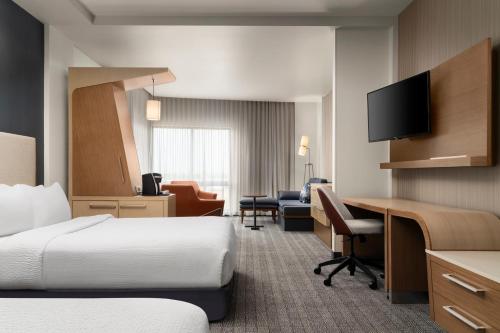 a hotel room with two beds and a desk at Courtyard by Marriott Denver North/Westminster in Eastlake