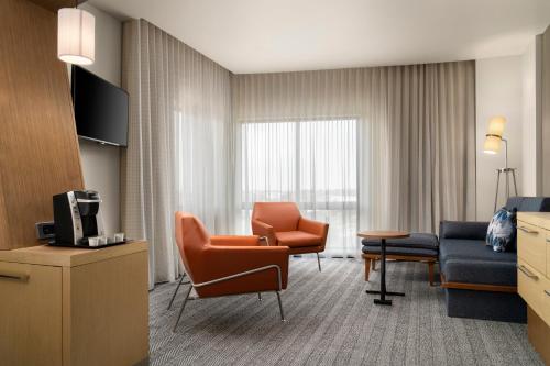 a hotel room with a couch and a chair at Courtyard by Marriott Denver North/Westminster in Eastlake