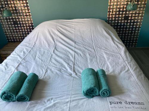 a bed with three green towels on it at Appartement Thout dichtbij zee in Ostend