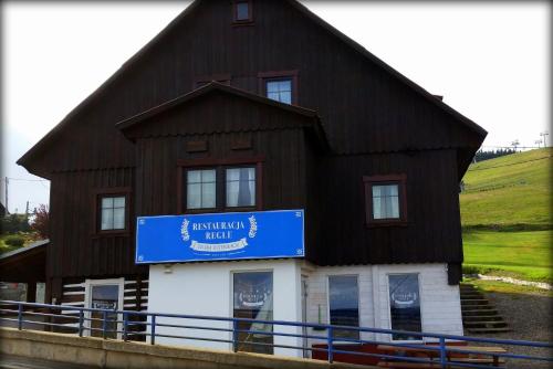 a large building with a blue sign on it at Ośrodek Wypoczynkowy Regle in Zieleniec