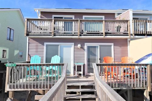 a house with two deck chairs and a balcony at On Slow Time in West Onslow Beach