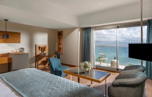 a hotel room with a bed and a view of the ocean at Liberty Kuşadası in Kusadası