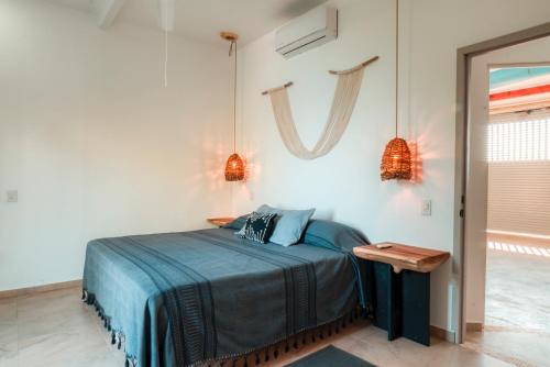 a bedroom with a bed with blue sheets and a table at Casa Gracias in Punta Mita