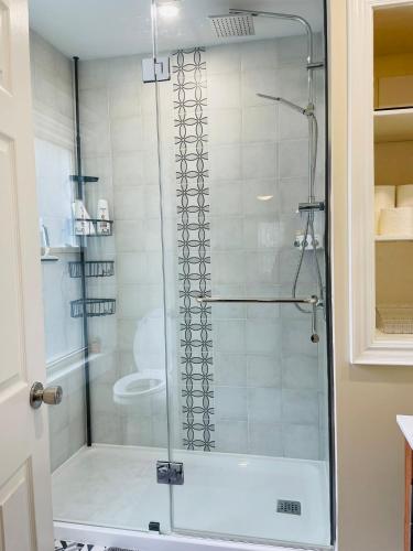 a shower with a glass door in a bathroom at Comfortable and Convenient Apartment in Central Niagara in St. Catharines