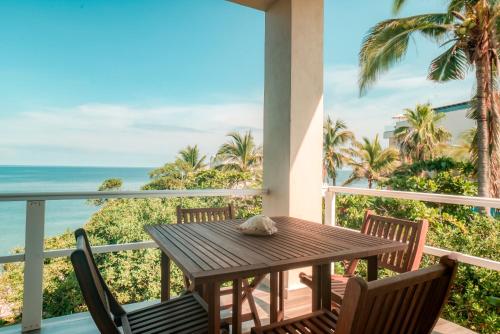 a table and chairs on a balcony with a view of the ocean at Casa Gracias in Punta Mita