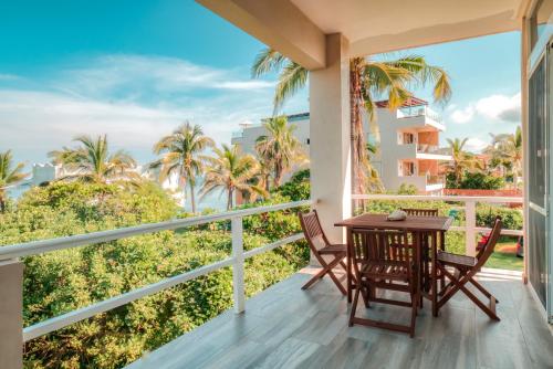 a balcony with a table and chairs and a view of the ocean at Casa Gracias in Punta Mita