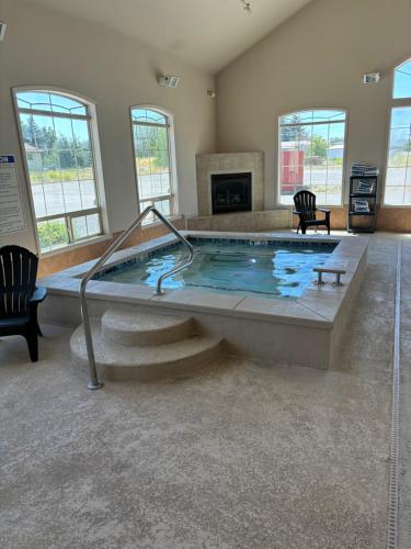 a large swimming pool in a room with a fireplace at Super 8 by Wyndham Rexburg in Rexburg