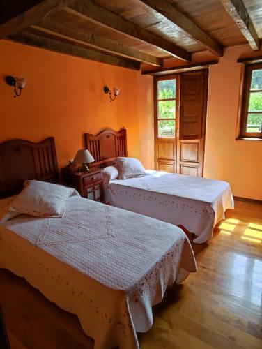 a bedroom with two beds in a room at Casa de Aldea CASA MON in Levinco