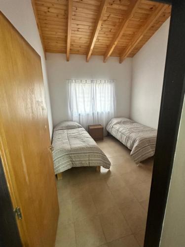 a bedroom with two beds in a room with wooden ceilings at Refugio Andino 2 in Malargüe