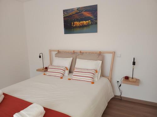 a bedroom with a large white bed with two pillows at Quinta do Tojo in Alufinha