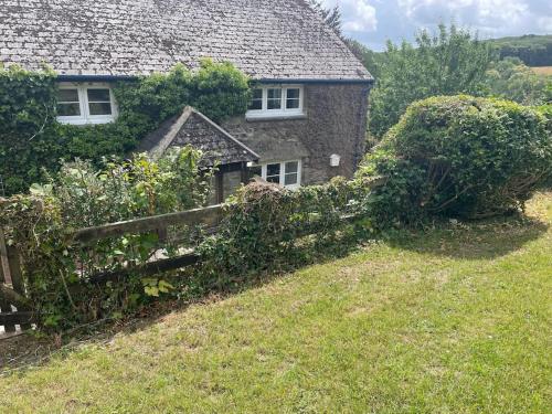 a house with a fence in front of it at The Cottage in Ashburton