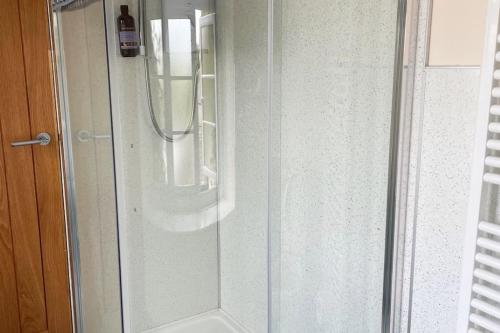 a shower with a glass door in a bathroom at The Cottage in Ashburton